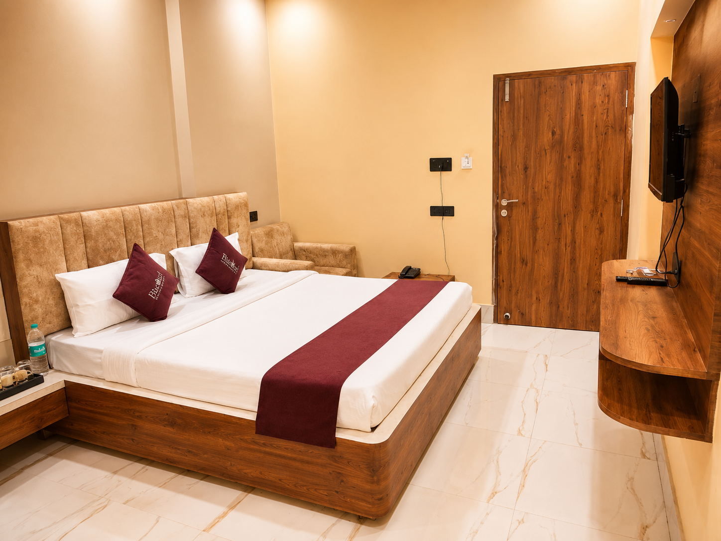 Deluxe Room bed and TV wall at Asha Palace